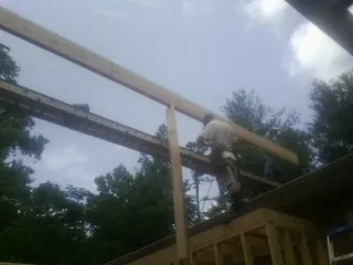 Carpenter setting a ridge beam over a new addition frame — Ice Dam Removal by Roofing Brothers in Castaic