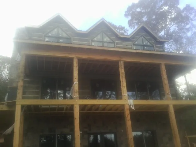 Dormers and porch framing on a large log home under construction — Roof Coating work by our crew in Castaic